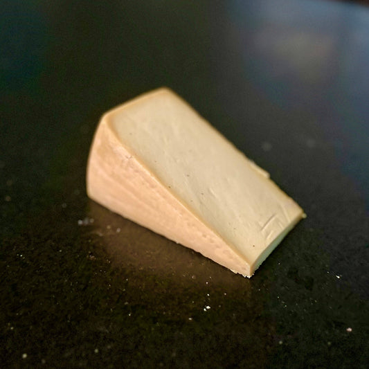 Triangular wedge of cheese on a dark surface