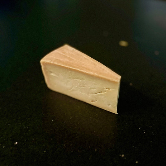Wedge of cheese on black surface